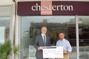 Mike Nicholls, presents the £500 cheque to Tim Richardson outside Chesterton office